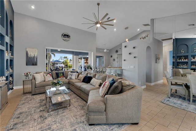 living room featuring light tile patterned floors, high vaulted ceiling, ceiling fan, and sink