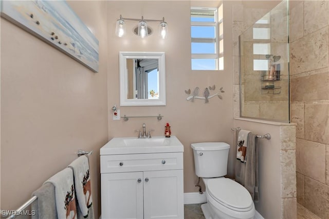 bathroom featuring tiled shower, vanity, and toilet