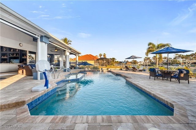 view of pool with pool water feature, ceiling fan, and a patio area