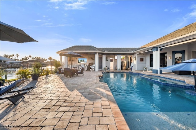 view of pool featuring an in ground hot tub and a patio