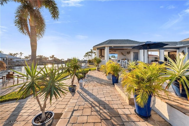 view of patio / terrace featuring a water view and ceiling fan