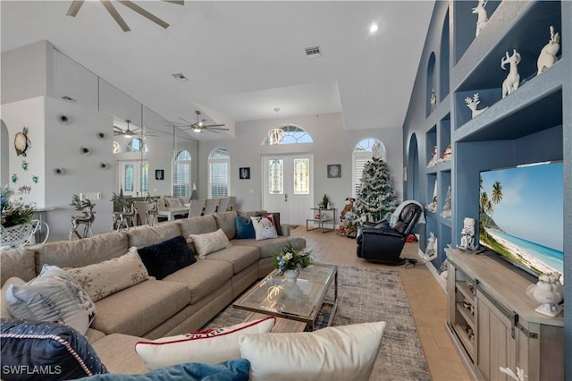 living room with ceiling fan, light hardwood / wood-style floors, and vaulted ceiling