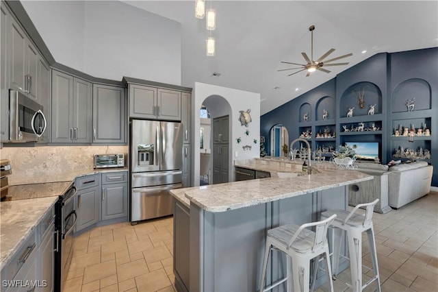 kitchen with gray cabinets, sink, lofted ceiling, and stainless steel appliances