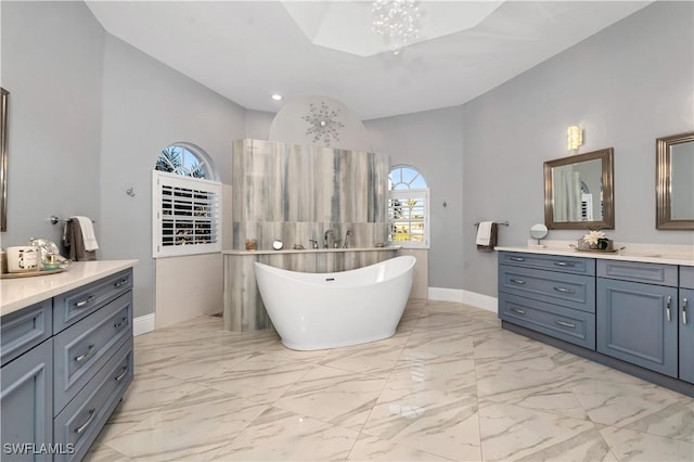 bathroom with a bathing tub, vanity, high vaulted ceiling, and an inviting chandelier