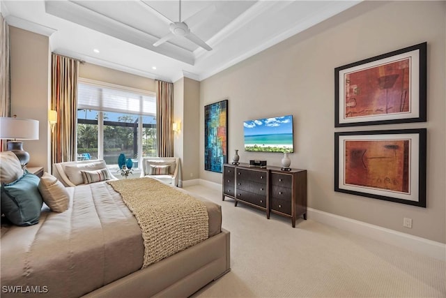 carpeted bedroom featuring ceiling fan, a raised ceiling, and ornamental molding