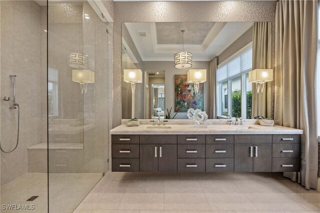 bathroom featuring a raised ceiling, tile patterned floors, vanity, and tiled shower