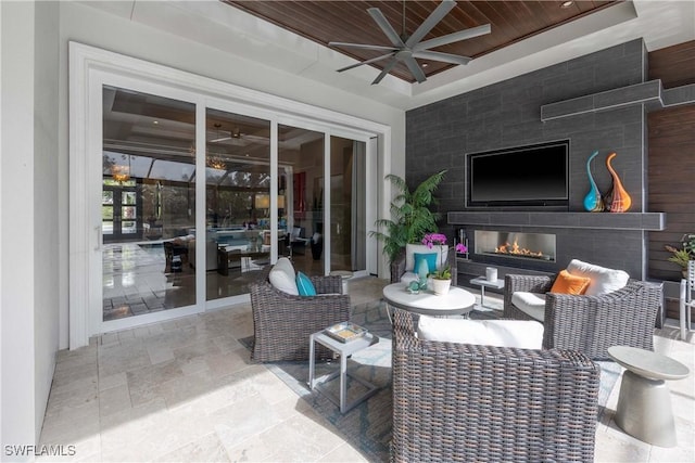 view of patio with an outdoor living space with a fireplace and ceiling fan