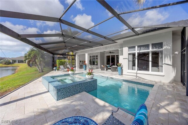 view of swimming pool with an in ground hot tub, ceiling fan, a water view, glass enclosure, and a patio area