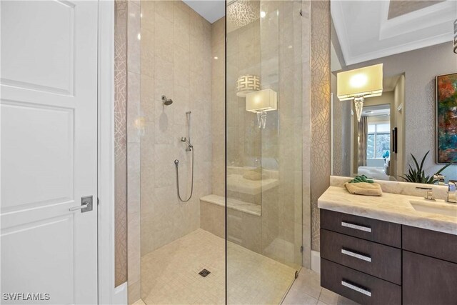 bathroom with tiled shower, tile patterned floors, vanity, and ornamental molding