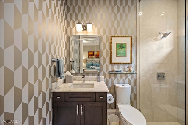 bathroom featuring a tile shower, vanity, toilet, and tile walls