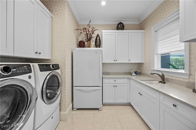 washroom with cabinets, ornamental molding, sink, washer and dryer, and light tile patterned floors