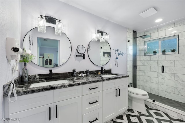 bathroom featuring tile patterned flooring, vanity, toilet, and a shower with door