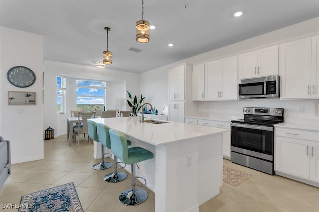 kitchen with white cabinetry, sink, decorative light fixtures, and appliances with stainless steel finishes