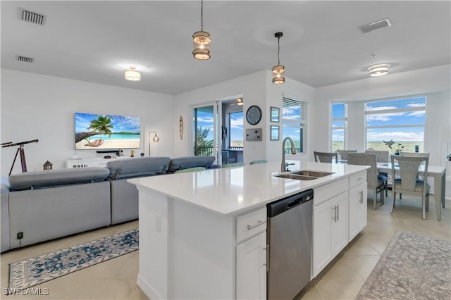 kitchen featuring pendant lighting, sink, stainless steel dishwasher, an island with sink, and white cabinetry