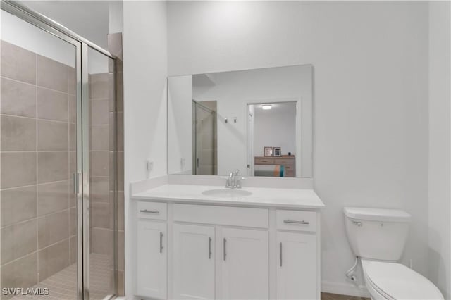 bathroom with vanity, toilet, and a shower with shower door