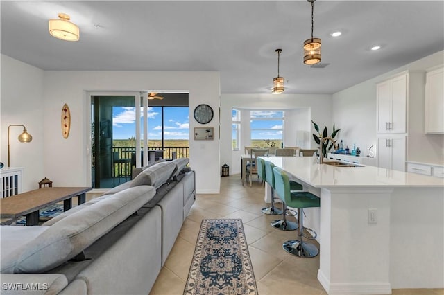 living room featuring sink and light tile patterned floors