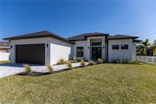 prairie-style house with a garage and a front lawn