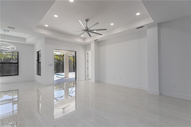 unfurnished room with a tray ceiling and ceiling fan