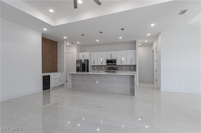 kitchen featuring white cabinetry, sink, a large island, stainless steel appliances, and pendant lighting