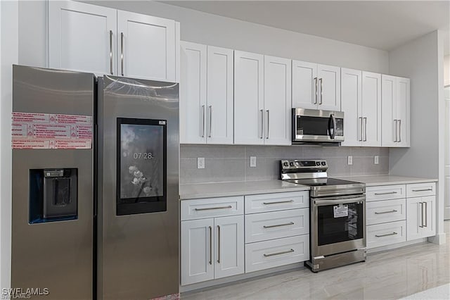 kitchen featuring tasteful backsplash, white cabinets, and appliances with stainless steel finishes