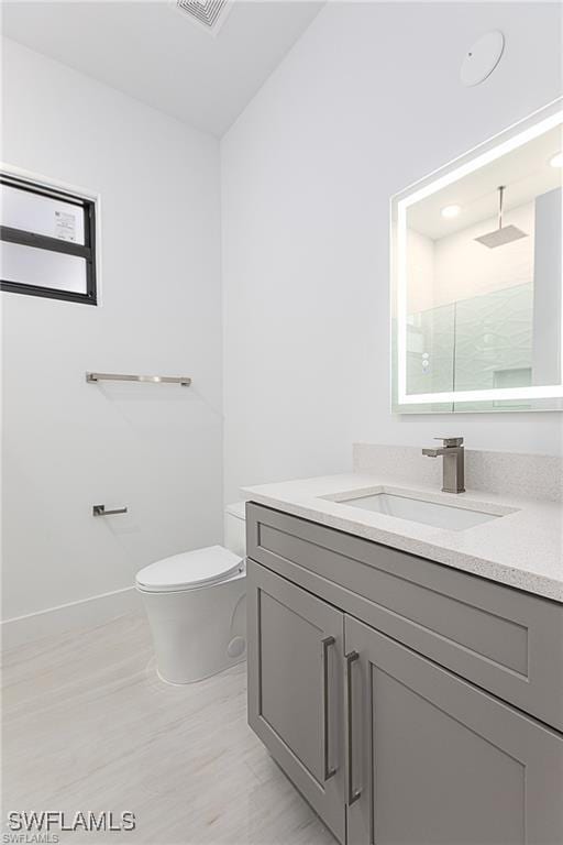 bathroom with vanity, toilet, and a shower with shower door