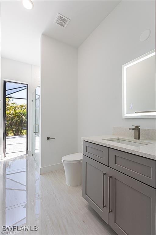 bathroom with vanity, toilet, and walk in shower