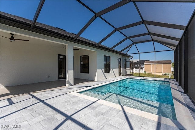 view of pool featuring glass enclosure, ceiling fan, and a patio area