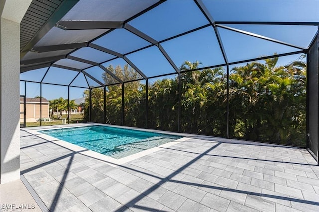 view of pool with glass enclosure and a patio