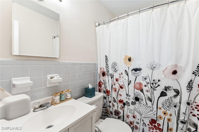 bathroom featuring vanity, toilet, curtained shower, and tile walls