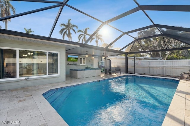 view of swimming pool featuring ceiling fan, outdoor lounge area, a patio area, and a lanai