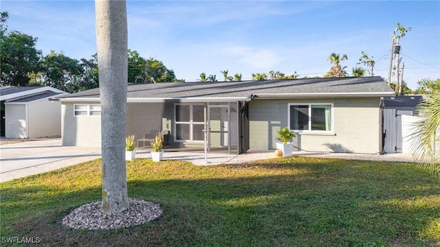 single story home featuring a sunroom, a patio area, and a front lawn