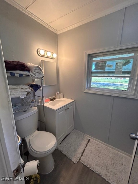 bathroom featuring crown molding, hardwood / wood-style floors, vanity, and toilet