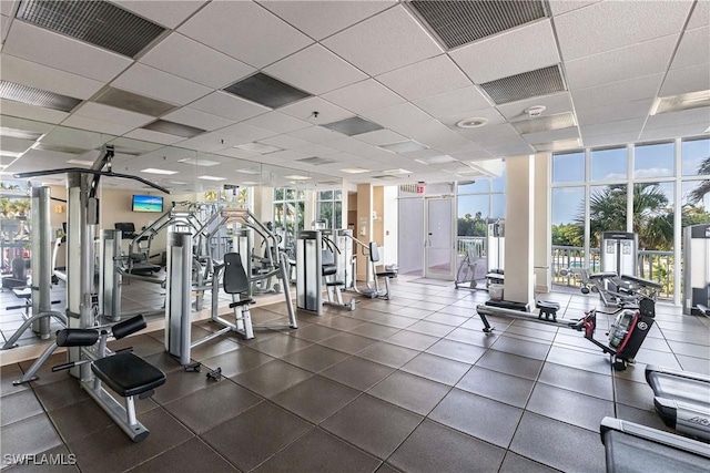 exercise room featuring a paneled ceiling and floor to ceiling windows