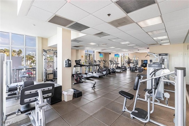 exercise room featuring a paneled ceiling and plenty of natural light