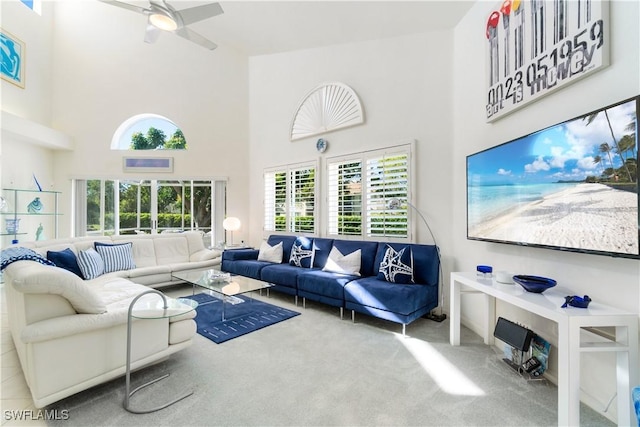 living room featuring carpet, a high ceiling, and ceiling fan