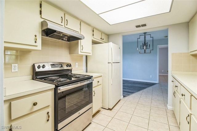 kitchen with backsplash, light tile patterned floors, electric range, white fridge, and hanging light fixtures