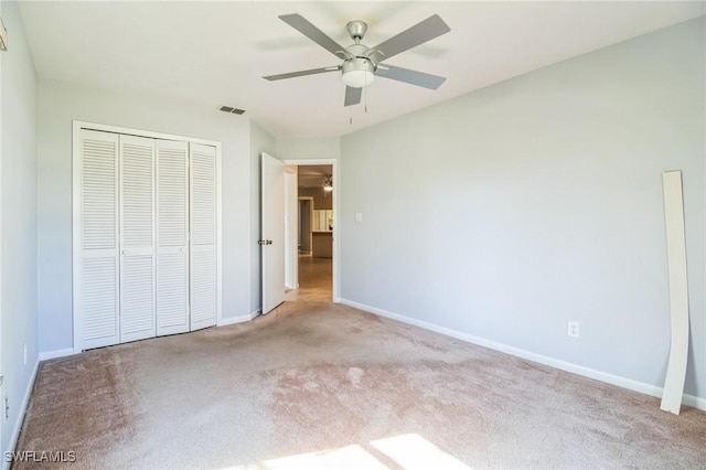 unfurnished bedroom featuring ceiling fan, light colored carpet, and a closet