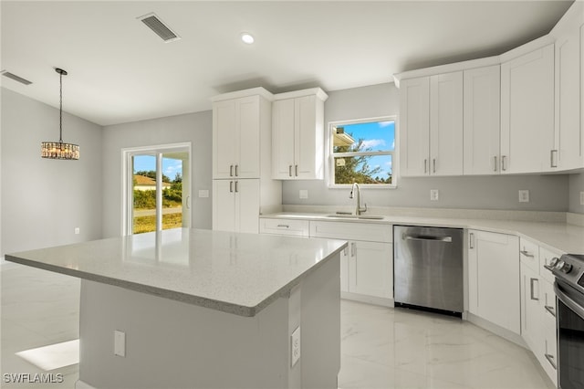 kitchen featuring a kitchen island, white cabinetry, sink, and appliances with stainless steel finishes