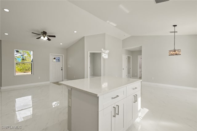 kitchen featuring ceiling fan, white cabinets, a center island, hanging light fixtures, and lofted ceiling