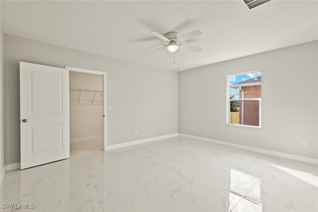 unfurnished bedroom with a walk in closet, ceiling fan, and a closet