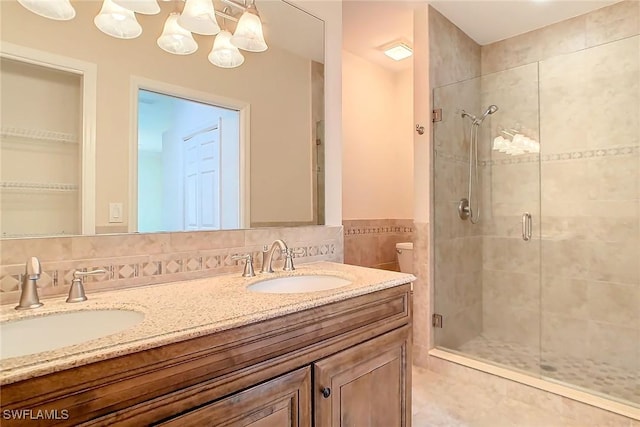 bathroom with vanity, a shower with door, and tile walls