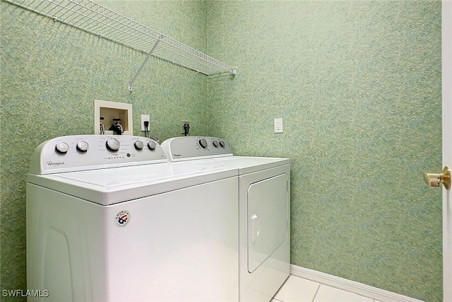 clothes washing area featuring light tile patterned floors and washing machine and clothes dryer