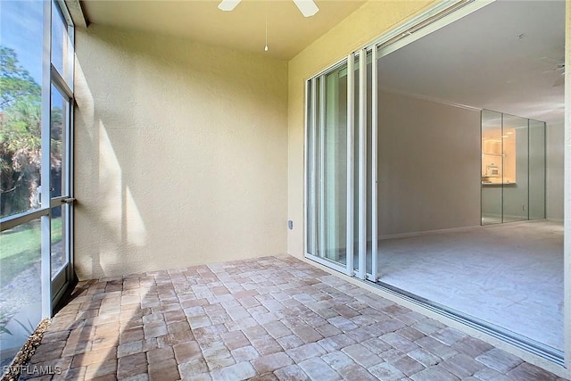 unfurnished sunroom featuring ceiling fan