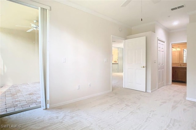 unfurnished bedroom featuring light colored carpet, ensuite bath, ceiling fan, and crown molding