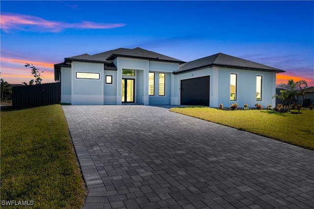 view of front facade with a yard and a garage