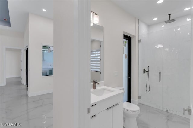 bathroom featuring toilet, vanity, and a shower with shower door