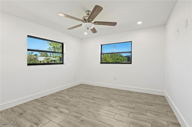 unfurnished room with light hardwood / wood-style flooring, a wealth of natural light, and ceiling fan