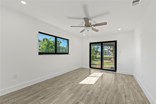 spare room featuring ceiling fan, a healthy amount of sunlight, and light hardwood / wood-style floors