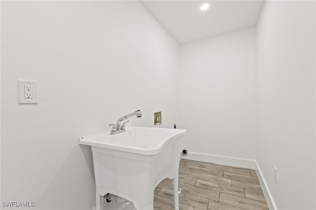 laundry room with light hardwood / wood-style floors, sink, and hookup for a washing machine