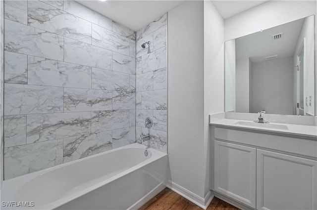 bathroom featuring vanity, wood-type flooring, and tiled shower / bath combo